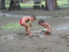 Embara children playing in puddle